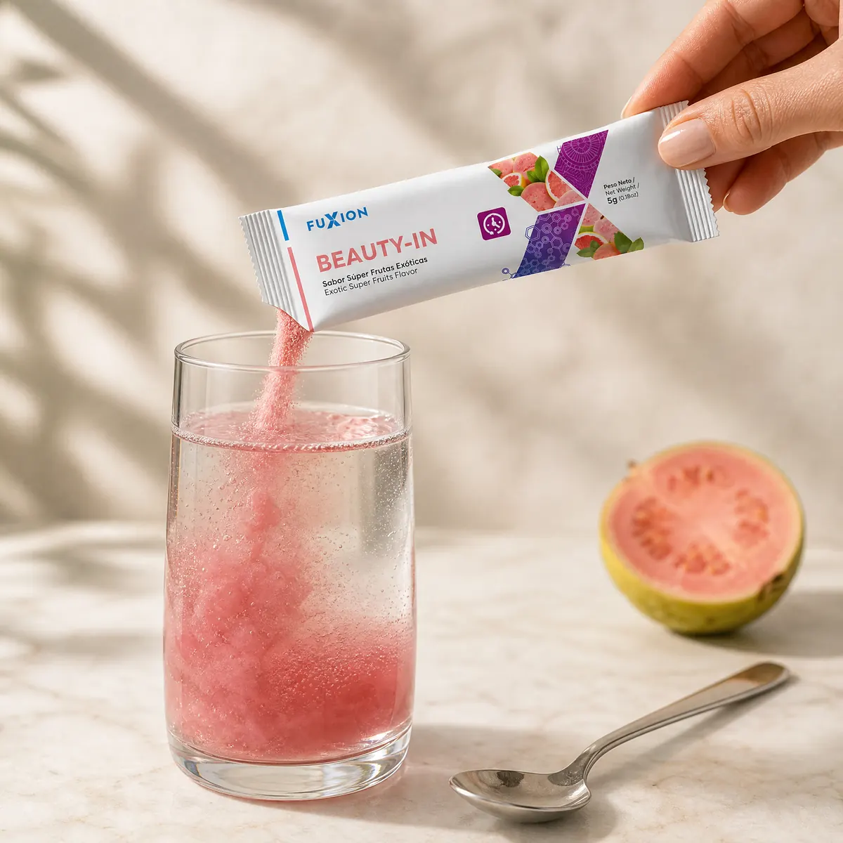 Mano volcando un stick de Beauty-In en un vaso de agua fría que se vuelve rosado
